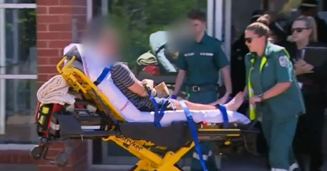 O homem de 49 anos foi levado ao hospital, com as mãos colocadas em sacos de papel. ele foi acusado de assassinato.