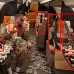 Jake Paul sentado em um jato particular cercado por dinheiro e várias armas de fogo.