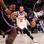 O guarda do New York Knicks, Jalen Brunson, entra na quadra com a bola de basquete.
