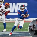 O quarterback Jaxson Dart #6 do New York Giants corre com a bola enquanto é perseguido por um jogador do Washington Commanders.