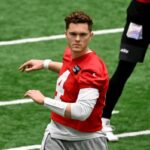 O quarterback dos Jets, Brady Cook (4), se alonga no treino em Florham Park, NJ.