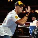 John Cena em um ringue de luta livre, vestindo uma camiseta branca e um boné amarelo com “U Can't C Me”.
