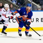 Jonathan Drouin jogando o disco contra Anthony Beauvillier durante um jogo de hóquei no gelo.