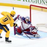 Jonathan Quick nº 32 do New York Rangers defende um chute de Filip Forsberg nº 9 do Nashville Predators no terceiro período na Bridgestone Arena em 21 de dezembro de 2025 em Nashville, Tennessee.