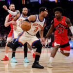 O guarda do New York Knicks, Josh Hart, vai até a cesta enquanto o guarda do Toronto Raptors, Jamal Shead, o persegue.