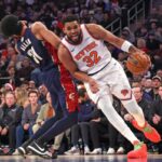 O pivô Karl-Anthony Towns #32 do New York Knicks é punido por uma falta ofensiva ao acertar o pivô Jarrett Allen #31 do Cleveland Cavaliers durante o primeiro quarto.