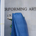 Lonas são instaladas em frente à placa do Kennedy Center na sexta-feira, 19 de dezembro de 2025, em Washington. (Foto AP/Mark Schiefelbein)