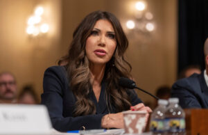 Kristi Noem forçada a enfrentar veterano de guerra condecorado que ela deportou Desenho animado de Clay Bennett