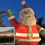 Papai Noel gigante inflável em um lote de árvores de Natal no Arizona.