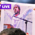 O jovem sentou-se e ficou no cais com o horizonte urbano e arranha-céus em Marina Bay Singapura.