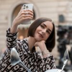 Emily tirando uma selfie. Na foto: Lily Collins.