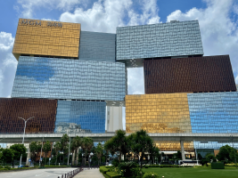 MGM Resorts estende acordo de marca enquanto MGM China fortalece desempenho em Macau MGM Resorts estende acordo de marca à medida que a MGM China fortalece o desempenho de Macau. Moderno complexo resort MGM Cotai em Macau com design de torre empilhada de vidro e ouro, palmeiras em primeiro plano e céu azul acima.