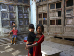 Mais crianças estão morrendo – graças a Trump ARQUIVO - Flores e uma placa são colocadas fora da sede da Agência dos EUA para o Desenvolvimento Internacional, ou USAID, 7 de fevereiro de 2025, em Washington. (AP Photo/José Luis Magana, arquivo)