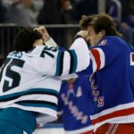 O pivô do New York Rangers, Matt Rempe, e o ala direito do San Jose Sharks, Ryan Reaves, brigando durante um jogo de hóquei.
