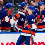 O defensor do New York Islanders, Matthew Schaefer (48), patina com o disco.