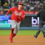 O defensor esquerdo do Cincinnati Reds, Austin Hays (12), avança para a terceira base em um single do primeiro base do Cincinnati Reds, Spencer Steer (7) (não retratado) durante a sétima entrada contra o Los Angeles Dodgers durante o primeiro jogo da rodada Wildcard para os playoffs da MLB de 2025 no Dodger Stadium.