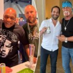 Ric Flair, Mike Tyson e um homem barbudo posando juntos.