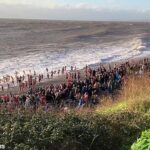 Momentos depois de esta fotografia ter sido tirada, os nadadores do dia de Natal enfrentaram dificuldades e dois nadadores se perderam no mar em Budleigh Salterton, em Devon.