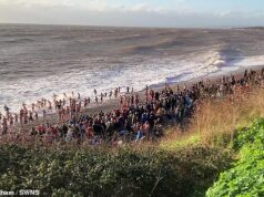 Minutos para o desastre da natação no dia de Natal: momentos depois que esta foto foi tirada, dois nadadores desapareceram quando a tragédia atingiu a tradição festiva Momentos depois de esta fotografia ter sido tirada, os nadadores do dia de Natal enfrentaram dificuldades e dois nadadores se perderam no mar em Budleigh Salterton, em Devon.