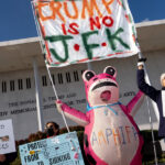 Lonas são instaladas em frente à placa do Kennedy Center na sexta-feira, 19 de dezembro de 2025, em Washington. (Foto AP/Mark Schiefelbein)