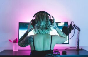 Netflix aposta em podcasts para se tornar o novo talk show diurno Image of a woman putting on headphones in front of a computer screen and microphone.