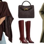 Diane Batoukina usa óculos escuros pretos, camiseta preta, casaco longo de couro marrom escuro brilhante, cinto pequeno Kelly de couro granulado preto brilhante da Hermes, calça jeans preta grande, bolsa Timeless de couro preto brilhante da Chanel, botins pretos de salto de couro brilhante, durante uma sessão de fotos de moda de estilo de rua, em 26 de outubro de 2022 em Paris, França.