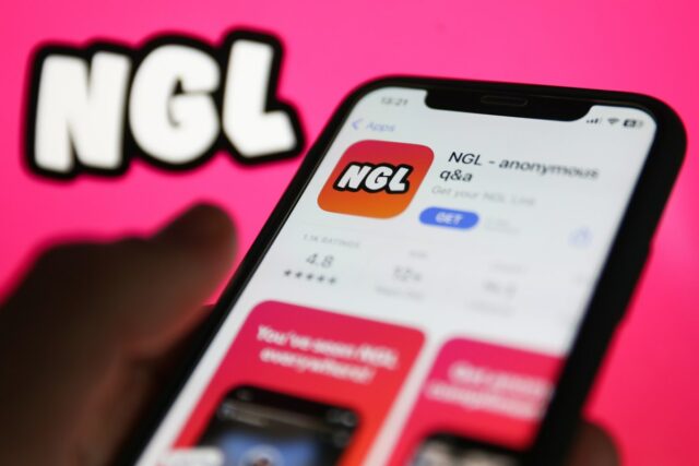 NGL on App Store displayed on a phone screen and NGL website displayed on a screen in the background are seen in this illustration photo