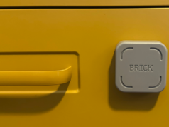 O bloqueador de tempo de tela Brick tem um valor ainda melhor quando várias pessoas o usam O tijolo em uma mesa de madeira.