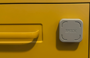 O bloqueador de tempo de tela Brick tem um valor ainda melhor quando várias pessoas o usam O tijolo em uma mesa de madeira.