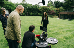 O diretor de fotografia de ‘Bugonia’, Robbie Ryan, fala sobre as filmagens de Bees, Basements e Emma Stone’s Bald Head Jesse Plemons e Emma Stone no set de