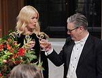O estranho Keir Starmer mal contém sua alegria ao sentar-se ao lado da supermodelo Claudia Schiffer antes de brindar com ela em um banquete oficial repleto de estrelas