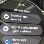 Mão saindo de um telefone segurando um cartão Gemini, com ícones de relâmpagos, brilhos e uma lâmpada ao redor