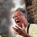 Policiais confortam Wong, 71, em meio ao incêndio em Hong Kong.