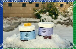 O inverno me transforma em um Grinch, mas as gomas de destilaria CBD estão me deixando feliz de novo Agricultor segurando sementes de cânhamo nas mãos, com o sol poente e plantas de cânhamo ao fundo.