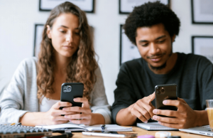 O mundo das apostas distorce os homens? Por dentro do crescente desequilíbrio de género na indústria O mundo das apostas distorce os homens? Uma mulher e um homem estão sentados lado a lado em uma mesa, olhando para seus smartphones em cadernos abertos, sugerindo que estão comparando informações ou participando juntos de uma atividade on-line.