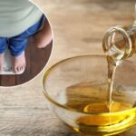 Derramando óleo de cozinha de uma jarra de vidro em uma tigela de vidro sobre uma mesa de madeira.