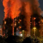 Pessoas em Hong Kong observam as chamas engolirem os arranha-céus.