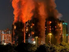 O que deu errado antes do inferno de apartamentos em Hong Kong Pessoas em Hong Kong observam as chamas engolirem os arranha-céus.
