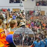 Os fãs de basquete da Taylor University invadem a quadra como parte da tradição icônica da 'Noite Silenciosa' durante a vitória por 118-33