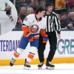 O juiz de linha Andrew Smith nº 51 patina Mathew Barzal nº 13 do New York Islanders até a grande área depois de ser chamado por golpe em Mason Marchment nº 17 do Columbus Blue Jackets durante o segundo período na Nationwide Arena em 28 de dezembro de 2025 em Columbus, Ohio.