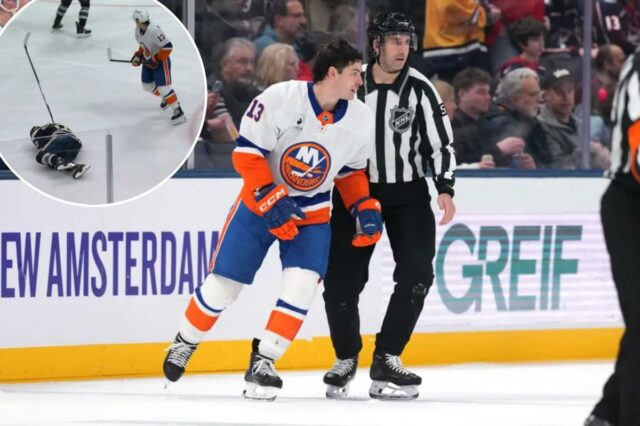 O juiz de linha Andrew Smith nº 51 patina Mathew Barzal nº 13 do New York Islanders até a grande área depois de ser chamado por golpe em Mason Marchment nº 17 do Columbus Blue Jackets durante o segundo período na Nationwide Arena em 28 de dezembro de 2025 em Columbus, Ohio.