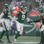 O lado defensivo do New York Jets, Will McDonald IV (9), comemora uma parada defensiva com seus companheiros.