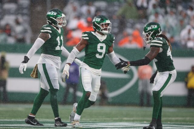 O lado defensivo do New York Jets, Will McDonald IV (9), comemora uma parada defensiva com seus companheiros.