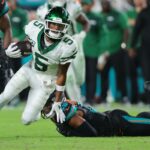O wide receiver do New York Jets, Garrett Wilson (5), ultrapassa o cornerback Artie Burns (23) do Miami Dolphins durante o segundo tempo no Hard Rock Stadium.