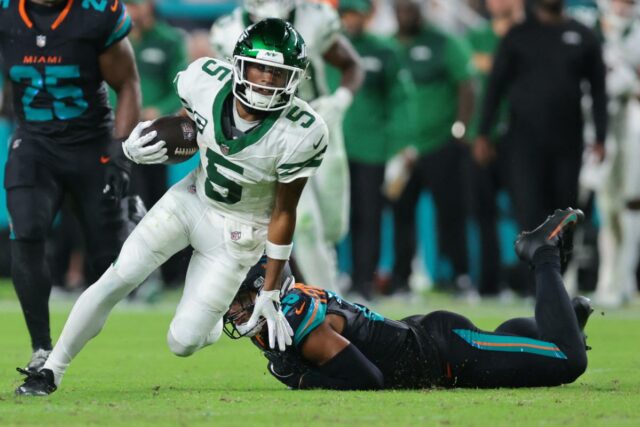 O wide receiver do New York Jets, Garrett Wilson (5), ultrapassa o cornerback Artie Burns (23) do Miami Dolphins durante o segundo tempo no Hard Rock Stadium.
