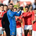 Edwin van der Sar comemora pelo Manchester United, vestindo uniforme roxo e braços levantados