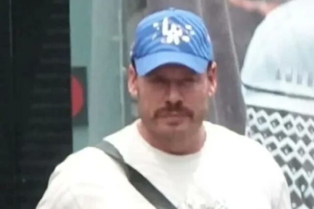 Ryan Wedding, homem de bigode e chapéu azul, procurado por tráfico de drogas, em foto de vigilância.