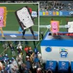 Duas pessoas fantasiadas de mascote Pop-Tart em uma plataforma em um jogo de futebol.