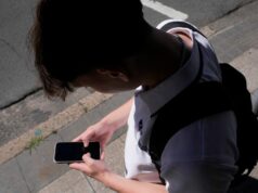 Por que os chatbots de IA caíram na linha de fogo de segurança online da Austrália Um adolescente usa seu telefone nas redes sociais em Sydney, 8 de novembro de 2024.