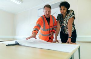 Por que os proprietários estão prestando mais atenção às credenciais dos empreiteiros homem mostrando suas credenciais de empreiteiro ao proprietário